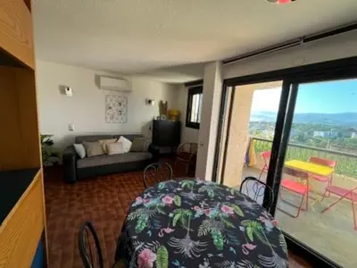 a living room with a couch and a balcony at Charmant 2 pièces avec vue sur mer exceptionnelle à Porticcio, Corse du Sud in Grosseto-Prugna