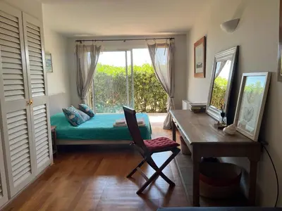 a bedroom with a bed and a desk and a window at Bonifacio accès mer et golf - vue exceptionnelle in Bonifacio