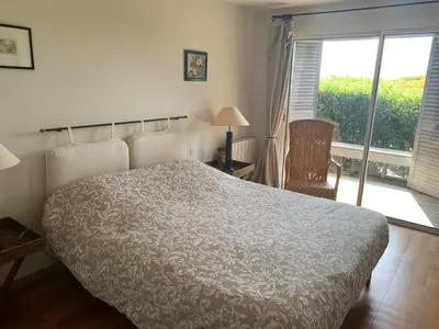 a bedroom with a bed and a window and a chair at Bonifacio accès mer et golf - vue exceptionnelle in Bonifacio