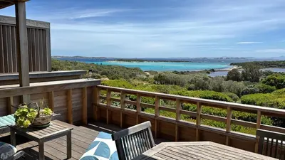 a balcony with a table and chairs and a view of the water at Bonifacio accès mer et golf - vue exceptionnelle in Bonifacio