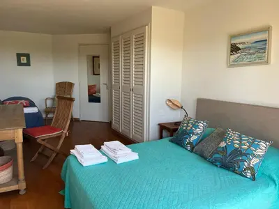 a bedroom with a bed and a table and a chair at Bonifacio accès mer et golf - vue exceptionnelle in Bonifacio