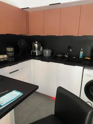 a kitchen with white cabinets and a black counter top at Porticcio Agosta in Albitreccia