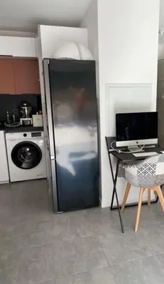 a refrigerator in a kitchen with a table and a computer at Porticcio Agosta in Albitreccia