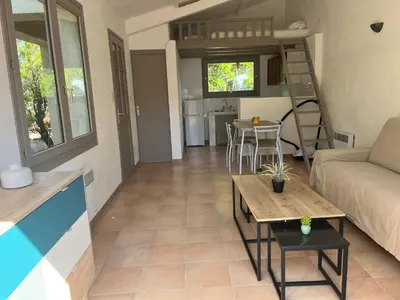 a living room with a couch and a table at Mini villa plage de saint cyprien in Lecci