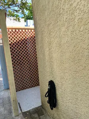 a black cat sitting on the side of a wall at Mini villa plage de saint cyprien in Lecci