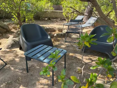 a group of chairs and a table and a table and chairs at Mini villa plage de saint cyprien in Lecci