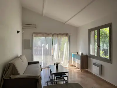 a living room with a couch and a table at Mini villa plage de saint cyprien in Lecci