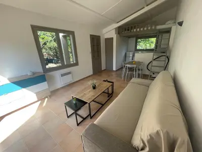 a living room with a couch and a table at Mini villa plage de saint cyprien in Lecci