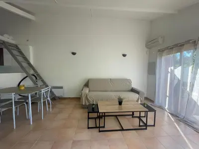 a living room with a couch and a table at Mini villa plage de saint cyprien in Lecci