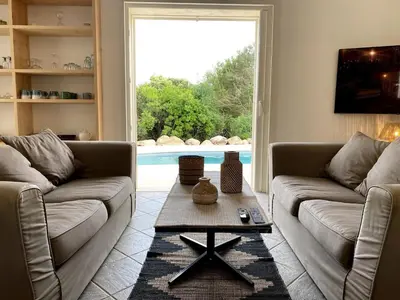 a living room with two couches and a table at Villa Porto Vecchio, calme avec piscine in Porto-Vecchio