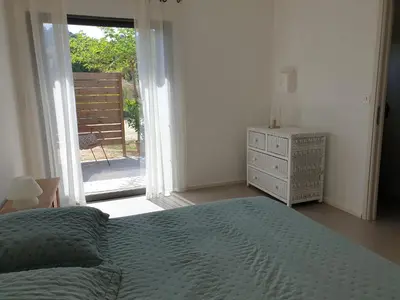 a bedroom with a bed and a door to a patio at Gozzi Mandriolu in Afa