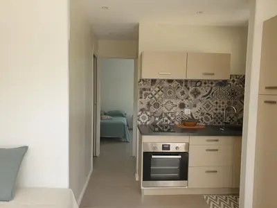 a kitchen with white cabinets and a stove at Gozzi Mandriolu in Afa