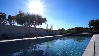 a swimming pool with the sun in the background at Villa Madra in Bonifacio