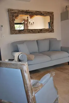a living room with a blue couch and a mirror at Villa Madra in Bonifacio