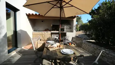 a wooden table with an umbrella on a patio at Villa Madra in Bonifacio