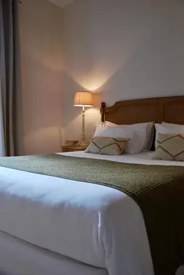 a bedroom with a large white bed with a lamp at Villa Madra in Bonifacio