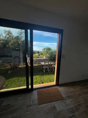 a sliding glass door with a view of a yard at casanova in Bonifacio