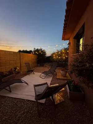 a patio with chairs and lights and a fence at casanova in Bonifacio