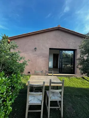 a wooden table and chairs in front of a house at casanova in Bonifacio
