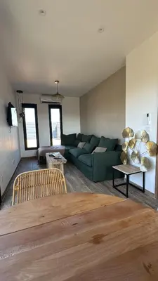 a living room with a green couch and a table at casanova in Bonifacio