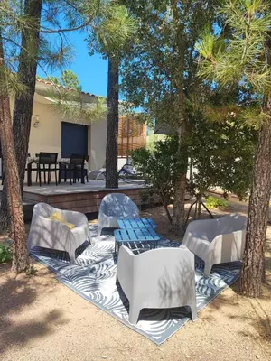 a house with palm trees and chairs in the yard at Villa à Lecci in Lecci
