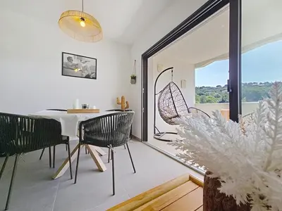 a dining room with a table and chairs and a window at appartement T2 rive sud porticcio vue mer in Pietrosella