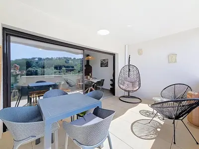 a living room with a table and chairs at appartement T2 rive sud porticcio vue mer in Pietrosella