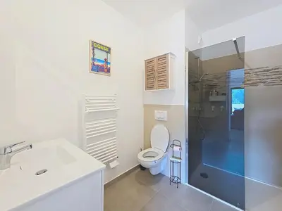 a bathroom with a toilet and a sink and a shower at appartement T2 rive sud porticcio vue mer in Pietrosella