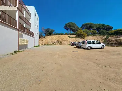 a car parked in a parking lot next to a building at appartement T2 rive sud porticcio vue mer in Pietrosella