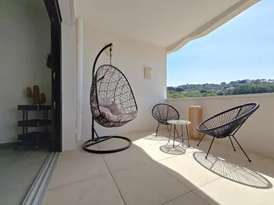 two chairs and a swing in a room with a window at appartement T2 rive sud porticcio vue mer in Pietrosella