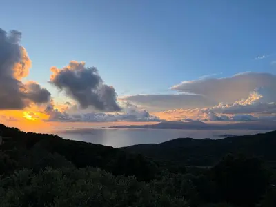 a view of the ocean from a mountain at sunset at RANDOS à 15 mn de la plage COTI CHIAVARI Vue exceptionnelle Appart indépendant 3 ch in Coti-Chiavari