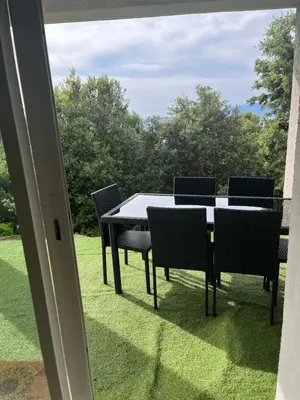a table and chairs on a patio with a view at RANDOS à 15 mn de la plage COTI CHIAVARI Vue exceptionnelle Appart indépendant 3 ch in Coti-Chiavari