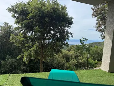 a blue bench sitting on top of a green field at RANDOS à 15 mn de la plage COTI CHIAVARI Vue exceptionnelle Appart indépendant 3 ch in Coti-Chiavari