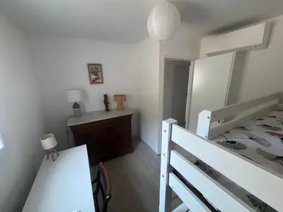 a bedroom with a bed and a table and a mirror at RANDOS à 15 mn de la plage COTI CHIAVARI Vue exceptionnelle Appart indépendant 3 ch in Coti-Chiavari
