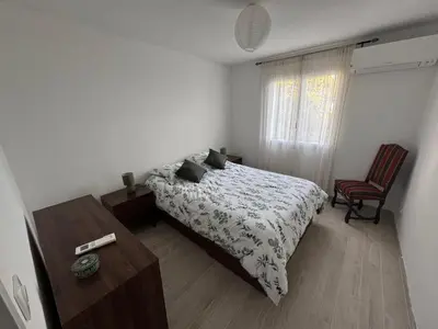 a bedroom with a bed and a table and a window at RANDOS à 15 mn de la plage COTI CHIAVARI Vue exceptionnelle Appart indépendant 3 ch in Coti-Chiavari
