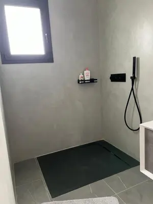 a corner of a room with a shower with a window at Maison 2 chambres in Figari