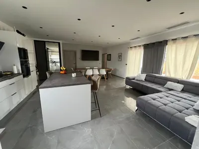 a kitchen and living room with a couch and a table at Maison 2 chambres in Figari