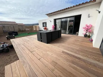a deck with a black cabinet on top of a house at Maison 2 chambres in Figari