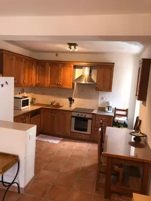 a kitchen with wooden cabinets and a stove top oven at Maison de village Frasseto in Frasseto