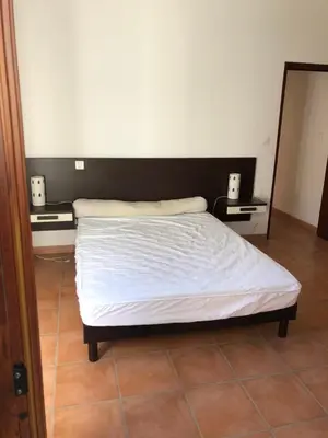 a bed in a room with two night stands and a mirror at Maison de village Frasseto in Frasseto