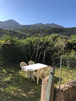 a white table and chairs with a view of a hill at Maison de village Frasseto in Frasseto