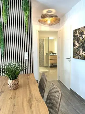 a dining room with a wooden table and chairs at T2 confort - résidence privée in Propriano