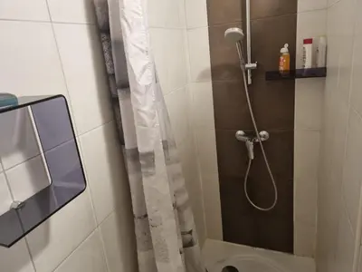 a bathroom with a shower with a shower curtain at T2, rez de villa avec piscine in Afa