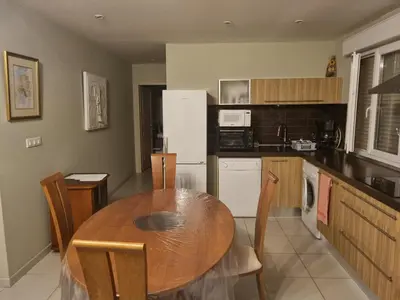 a kitchen with a wooden table and a dining room at T2, rez de villa avec piscine in Afa