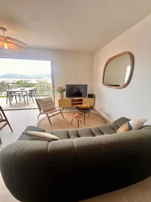 a living room with a couch and a television at Appartement CASA VISTA splendide vue sur le Golfe in Porto-Vecchio