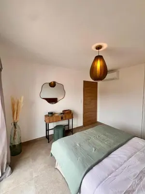 a bedroom with a bed and a desk and a lamp at Appartement CASA VISTA splendide vue sur le Golfe in Porto-Vecchio