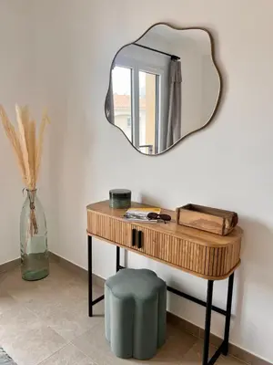 a mirror on a wall above a wooden table with a green stool at Appartement CASA VISTA splendide vue sur le Golfe in Porto-Vecchio