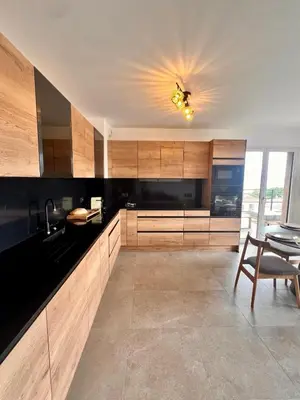 a kitchen with wooden cabinets and a table and a ceiling at Appartement CASA VISTA splendide vue sur le Golfe in Porto-Vecchio