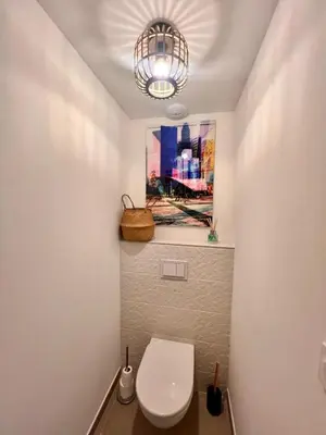 a bathroom with a toilet and a painting on the wall at Appartement CASA VISTA splendide vue sur le Golfe in Porto-Vecchio