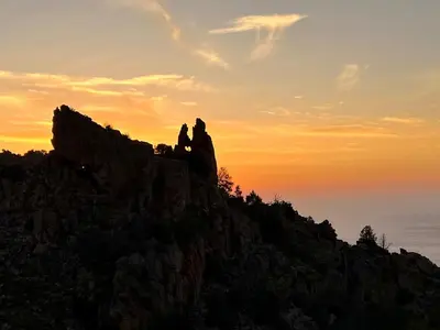two people sitting on top of a mountain at sunset at Spacieuse villa avec vue exceptionnelle in Piana